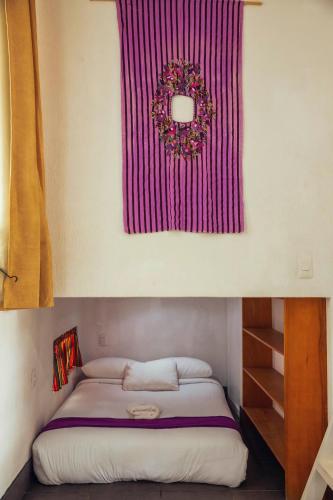 a bedroom with a bed with a red blanket on the wall at El Dragon Hotel in San Marcos La Laguna