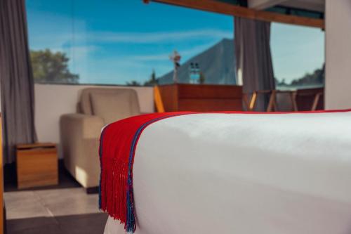 a bedroom with a bed with a red blanket on it at El Dragon Hotel in San Marcos La Laguna