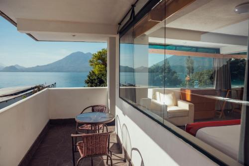 a room with a balcony with a table and chairs at El Dragon Hotel in San Marcos La Laguna