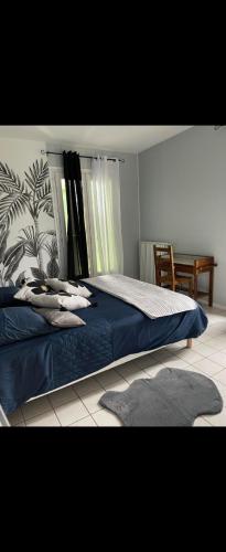 - une chambre avec un lit avec des draps bleus et une table dans l'établissement Maison familiale ou entre amis à la campagne, à Nanthiat