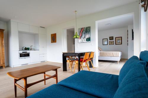 a living room with a blue couch and a table at Seehaus Herzog in Drobollach am Faakersee
