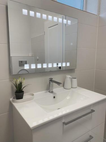 a white bathroom with a sink and a mirror at Silver Moon Residence 3 in Arad