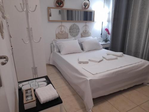a bedroom with a white bed and a mirror at Heraklion Centre Experiene in Heraklio