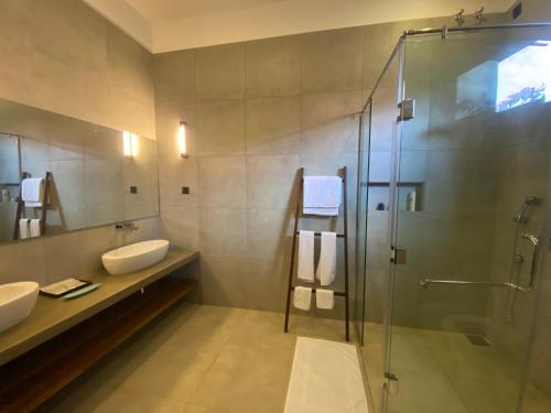 a bathroom with two sinks and a glass shower at Adaar in Trincomalee