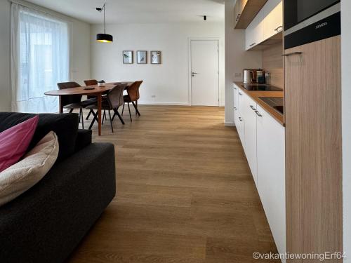 a kitchen and dining room with a couch and a table at Vakantiewoning Erf64 in Sint-Amands
