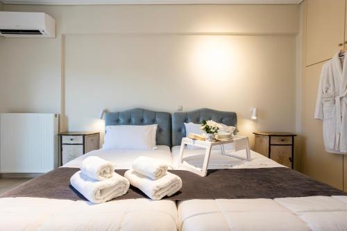 a bedroom with a large bed with towels on it at Villy's Comfort Zone Apartments in Kalamata