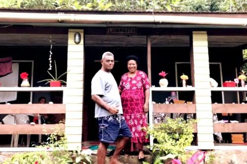a man and a woman standing on the porch of a house at Jolame Homestay Experience in Wayasewa Island