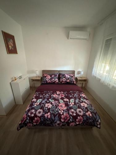 バニャ・コヴィリャチャにあるApartman Milinkovicのベッドルーム1室(花柄のベッドカバー付)