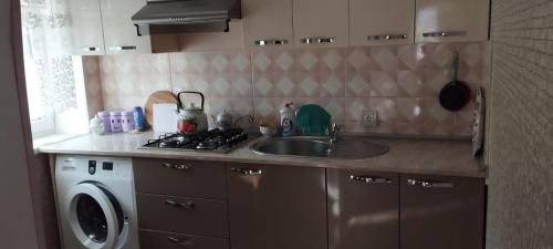 a kitchen with a sink and a washing machine at Gusar goust house int in Qayakǝnd