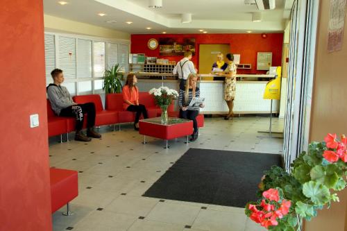 un groupe de personnes assises dans une salle d'attente dans l'établissement Olimpiska Centra Ventspils Hotel, à Ventspils