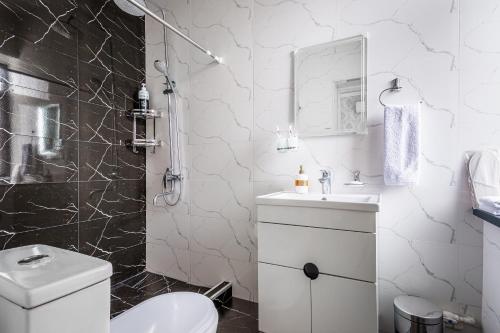 Un baño blanco con inodoro y lavabo. en Comfort Tashkent, en Tashkent