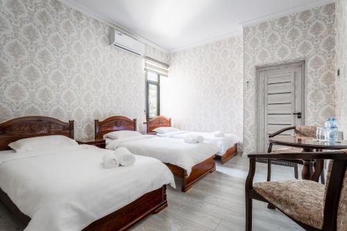 un grupo de cuatro camas en una habitación en Comfort Tashkent, en Tashkent