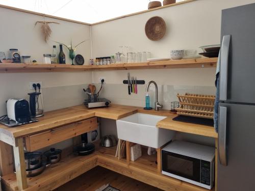 a kitchen with wooden shelves and a sink at הבוסתן של הדס, הדום שבהר in Yavneʼel