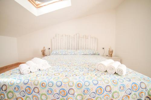 a white bedroom with a large bed with towels on it at Follow The Sun-Camera con terrazza fronte mare in Portoscuso
