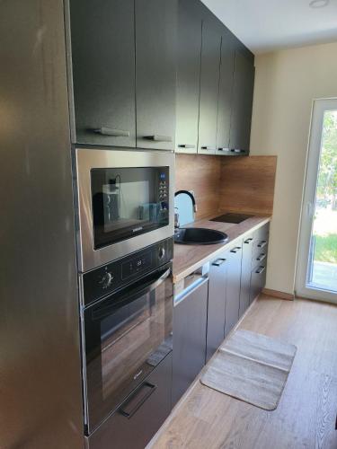 a kitchen with a stainless steel refrigerator and a sink at Chillhouse Császárszállás in Nyíregyháza