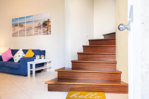 a living room with stairs and a blue couch at La Villetta delle Stelle in Viareggio