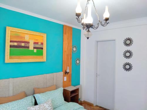 a living room with a couch and a blue wall at Jazmines Apart Olivos in Olivos