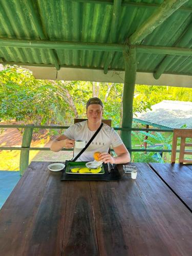 a man sitting at a table with a tray of food at Sigiri Prabha Villa in Sigiriya