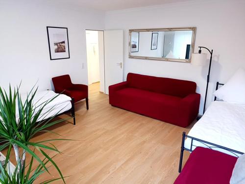un salon avec un canapé rouge et un lit dans l'établissement Ferienwohnung-Montagewohnung 3, à Bad Driburg