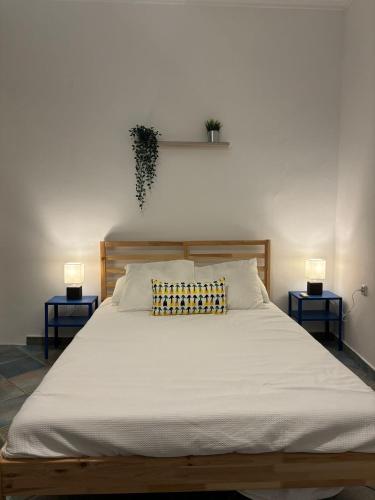 a large bed with two lamps on either side of it at Mountain View Apartment Lefkada in Apolpaina