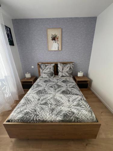 a bedroom with a bed with a gray wall at Résidence Lynda in Champigny-sur-Marne