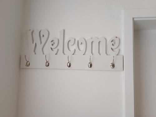 a sign that reads welcome in a white room at Apartma LANA in Koper