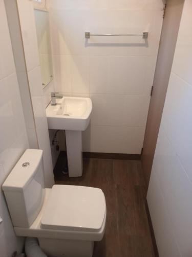 a bathroom with a white toilet and a sink at Yak City Apartments in Kandy