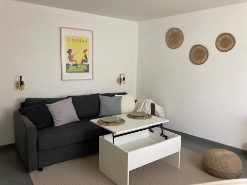 a living room with a couch and a table at Studio avec jardin in Agon Coutainville