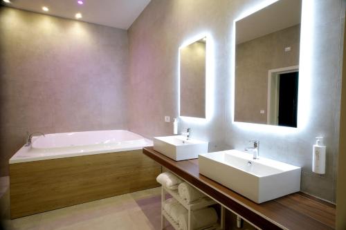 a bathroom with two sinks and a bath tub at Sebèl Camere di Charme in Barletta