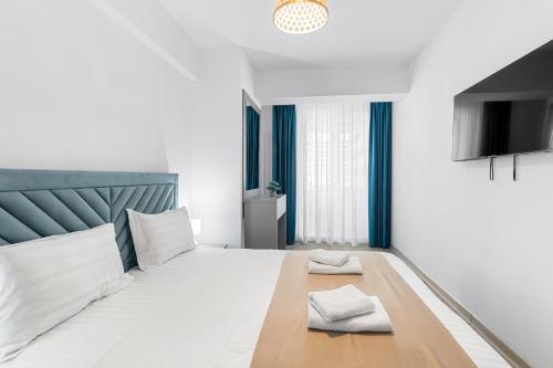 ein Schlafzimmer mit einem großen Bett mit zwei Handtüchern darauf in der Unterkunft Chill Side - Infinity Pool & Spa Resort in Mamaia Nord – Năvodari