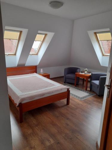 a bedroom with a bed and a couch and windows at Dom Gościnny Pola in Rewal