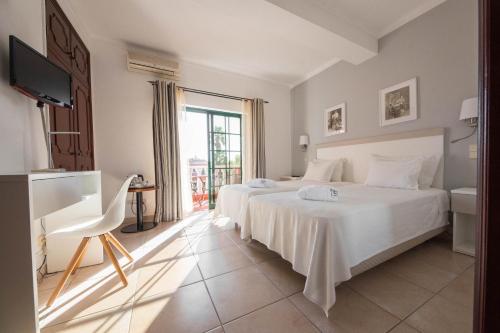 a hotel room with two beds and a television at Solar de Mos in Lagos