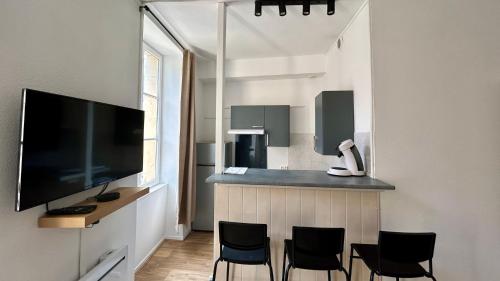 Il dispose d'une cuisine équipée d'un bar avec des chaises et d'une télévision à écran plat. dans l'établissement La parenthèse, à Nevers