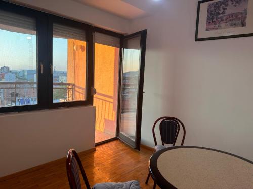 a table and chairs in a room with a balcony at Sparta- Minimalism in Kavadarci