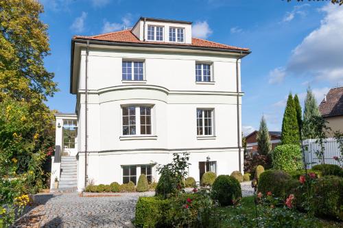 a white house with a red roof at Romantický apartmán se starožitným interiérem in Mořina