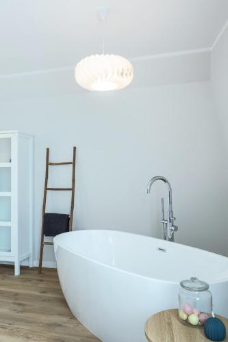 a white bath tub in a bathroom with a chair at Heima in Zawoja