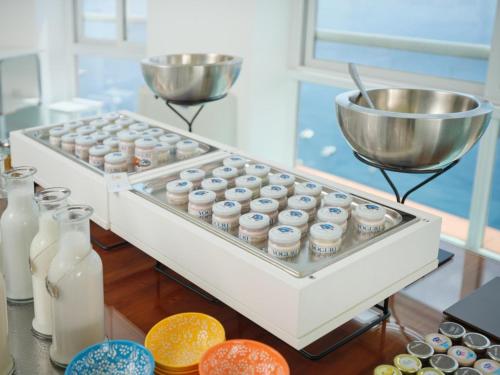 a row of milk bottles and a bowl on a counter at Hotel Le Agavi in Positano
