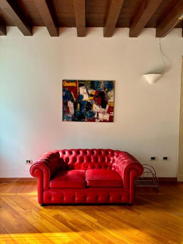 a red couch in a room with a painting on the wall at Casa Martita in Taglio di Po