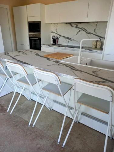 a kitchen with a counter with chairs around it at Villa Cirasa in Aragona