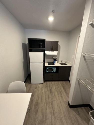 a small kitchen with a refrigerator and a stove at Studio 6 Columbus GA Columbus Airport in Columbus