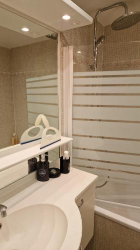 La salle de bains blanche est pourvue d'un lavabo et d'une baignoire. dans l'établissement Appartement lumineux en duplex avec terrasse et jardin, à Vaujours