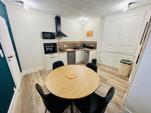 une cuisine avec une table et des chaises dans une pièce dans l'établissement Le coeur de Bourges, à Bourges