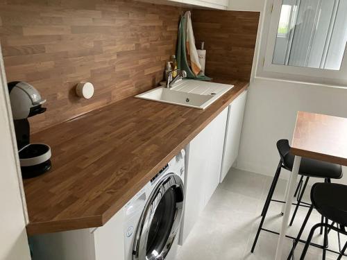 une cuisine avec un évier et une machine à laver dans l'établissement Spacieux Appartement Familial - 10 mnt du RER B, à Massy