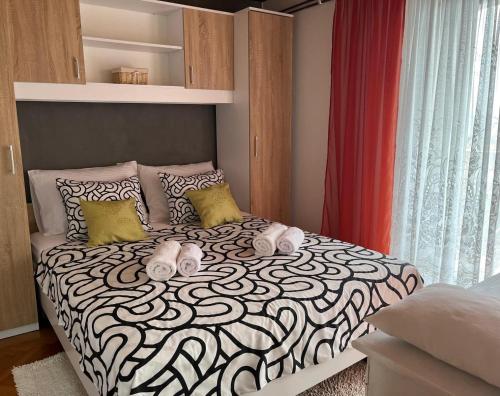 a bedroom with a bed with a black and white comforter at Apartman Petrić in Rijeka