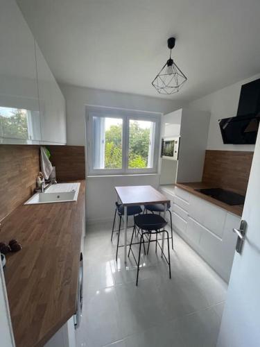 une cuisine avec une table, des chaises et un évier dans l'établissement Spacieux Appartement Familial - 10 mnt du RER B, à Massy