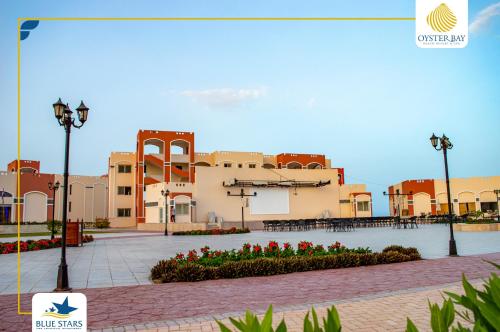 a building with red flowers in a courtyard at Oyster bay Suite 01 in Abu Dabab