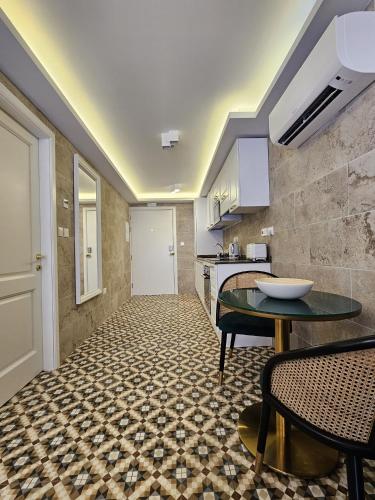 a living room with a table and a kitchen at Balcony Hotel in St Julian's