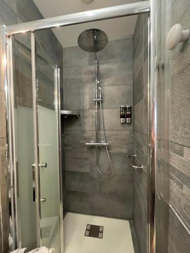 a shower with a glass door in a bathroom at L'Escale Arc-en-Ciel in Les Hayes