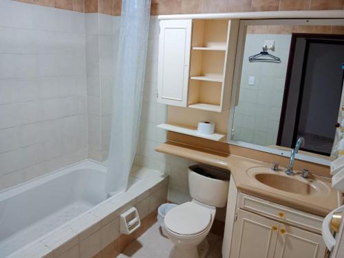 a bathroom with a toilet and a sink and a tub at apartaestudios luna azul rodadero in Gaira