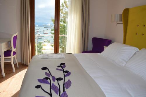 a bedroom with a bed and a window with a view at MYLA Hotel Tuzla in Tuzla